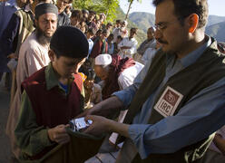IRC response member checking a child's vitals during the 2005 earthquake crisis in Pakistan.