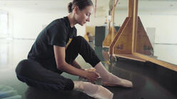Ballerina Christine tying her point shoes