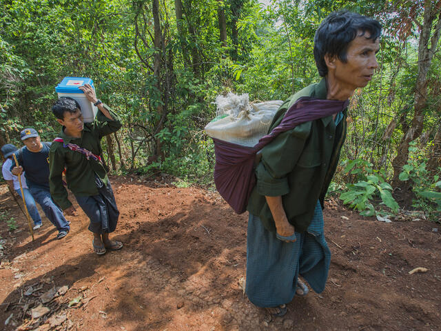 A mixed group of medics and nurses from the Burmese government and a former rebel group on their way to vaccinate children and bring other healthcare to a remote village in Myanmar’s eastern Kayah State.