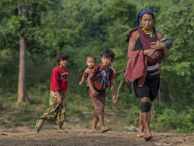 A woman and her children walk to receive vaccinations and medicines from the health team. 