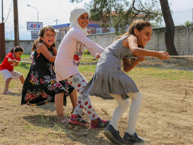 Four girls playing tug of war.