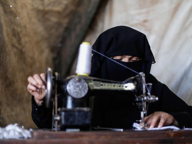 Wa'ad at her sewing machine in Syria making masks