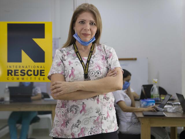 Dr Edna Patricia Gomez stands in front of the IRC medical clinic with her arms folded and mask on her chin.