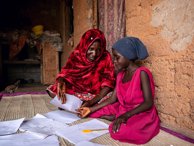 Fatima studying with help from her mother.