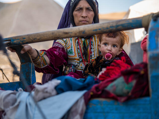 A mother rocks her sick child in a camp in Afghanistan.