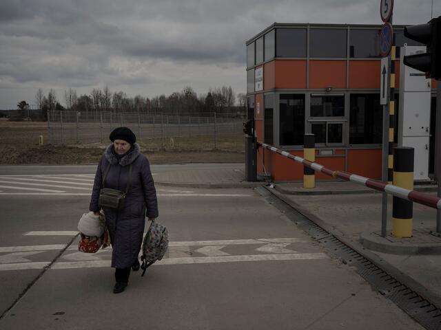 A Ukrainian woman and refugee at walking across the road at Medyka border crossing point
