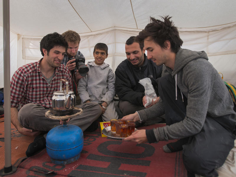 Men in tent making tea IRC Salam Neighbor team in tent in Zaatari camp