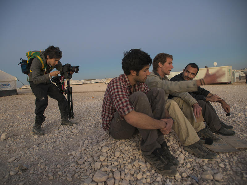 Men outside at dusk he Salam Neighbor team provides an evening wrap up of their day's activities at Zaatari camp
