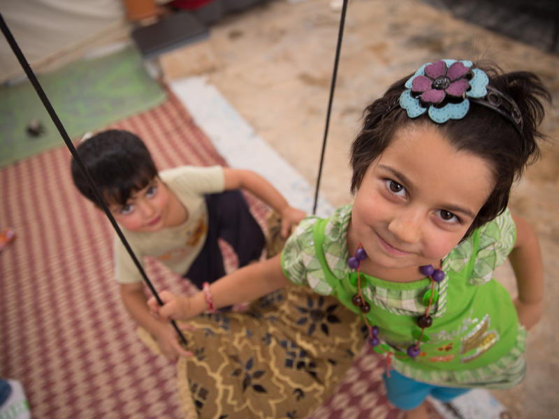 Syrian children play outside of their makeshift home in a Jordan Syrian children play outside of their makeshift home in a Jordan