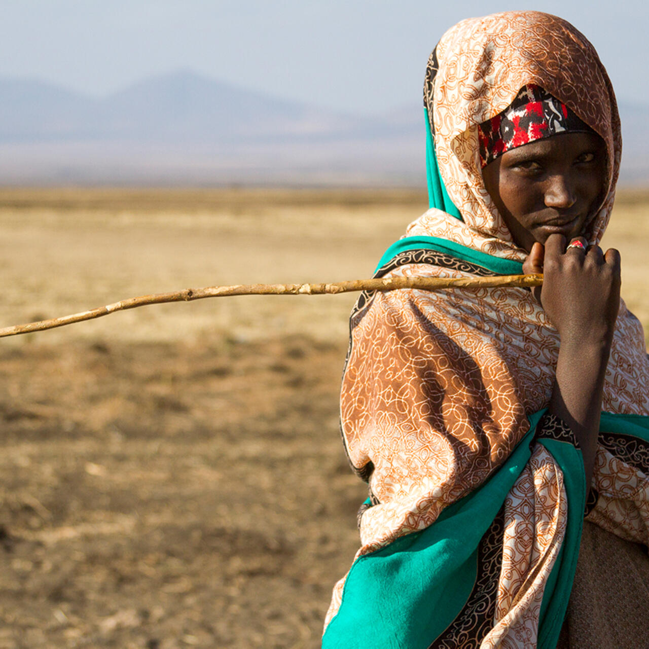 15 year old girl holding a stick stares at the camera in the drought affected Somali region of Ethiopia.
