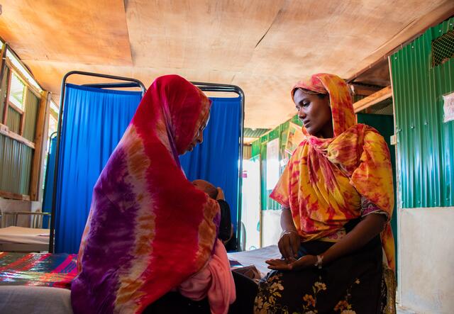 Fatima, right, visits Shahera and her newborn at the women's health center in Kutupalong. Volunteers like Fatima go door-to-door in the camp to encourage expectant mothers to visit the center before they are due.