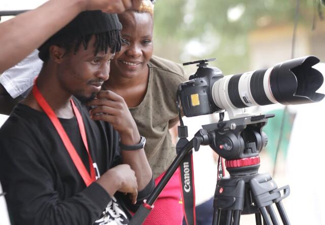 Film makers Amina and Abdul looking down a camera.