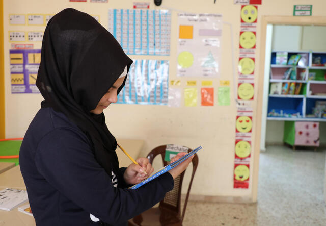 A young Syrian girl studying at the IRC-run safe space in Lebanon. 
