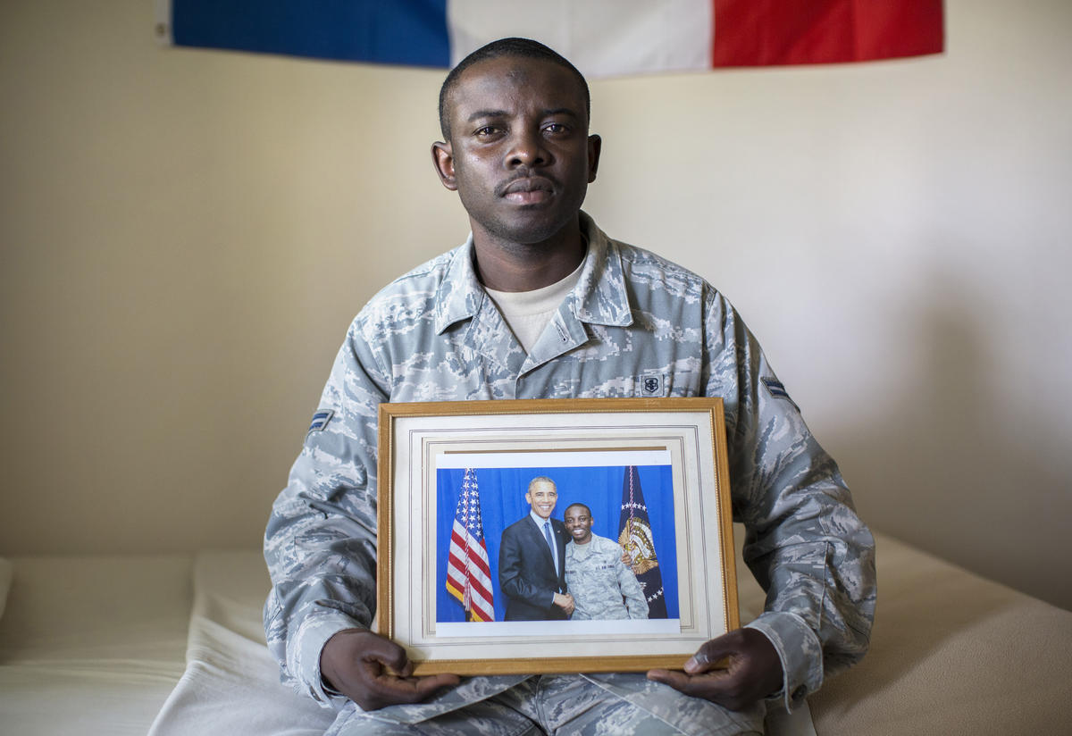 Nelson Rieu holds a photo of himself with Obama Nelson Rieu holds a photo of himself with Obama