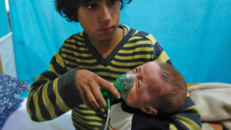 Young boy helps crying infant to breathe following chemical attack in Douma, Eastern Ghouta