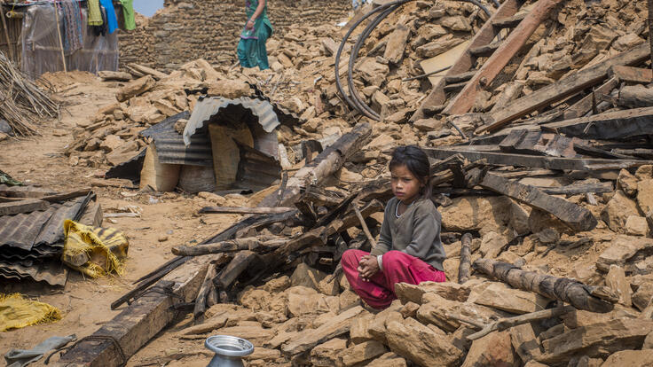 A girl sitting on the rubble of her collapsed house in Tasarphu, a village close to the quake's epicenter.