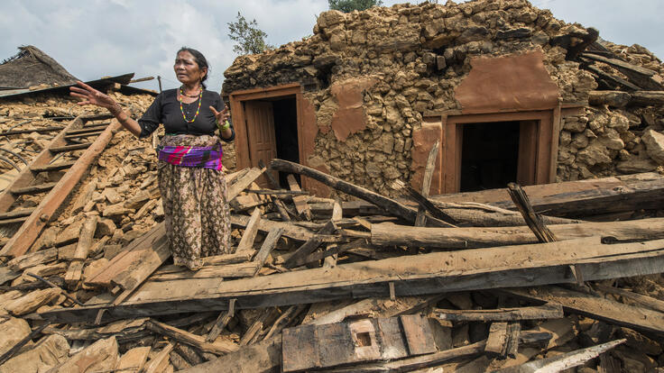 Sabitri Maya standing in the debris of her home.