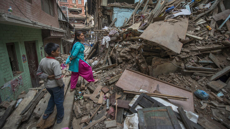 A woman and her son surveying their damaged home in Kathmandu.