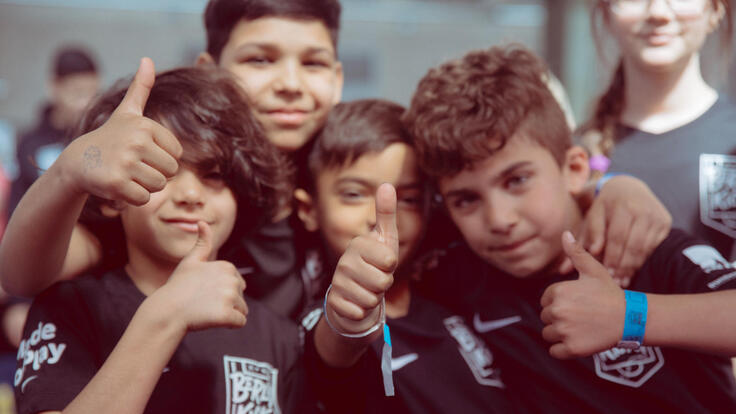 A group of boys holding thumbs up for a picture.